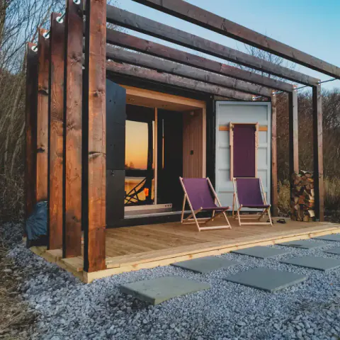 Exterior of a Pixxla sauna beside a lake.