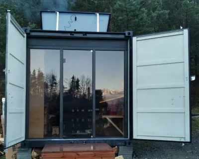 Glass front of the Poprad sauna reflecting the surrounding landscape.