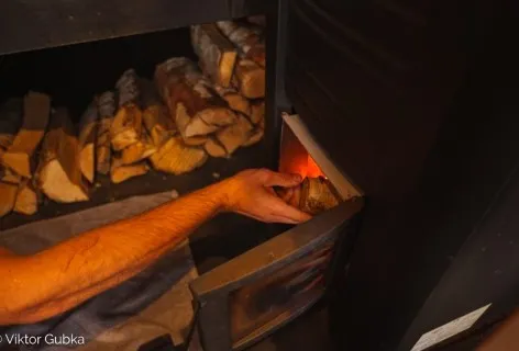 Lighting the wood-burning stove inside the Pixxla sauna at Sunny Lakes.
